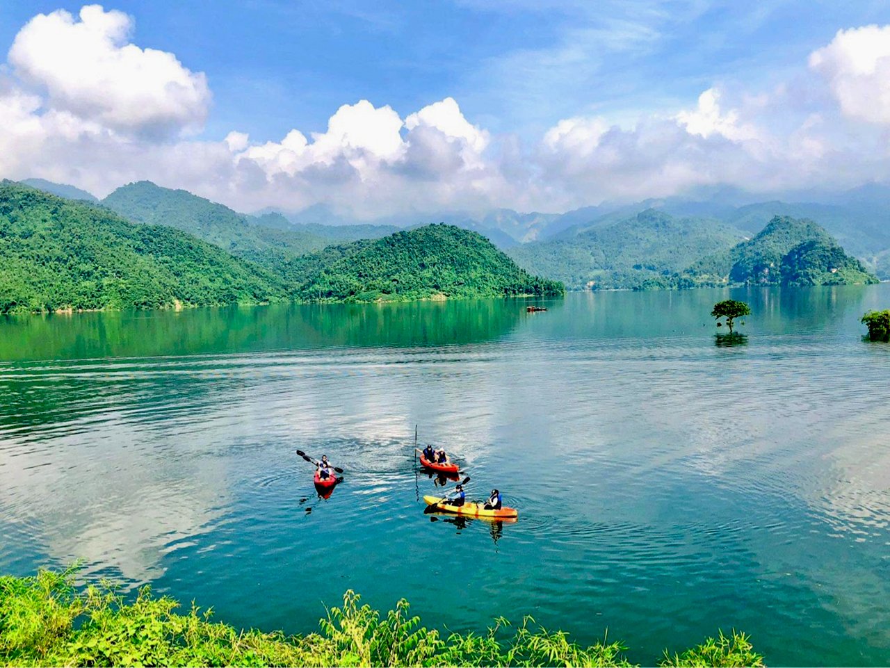 Boat passing floating houses and fish farms on the lake